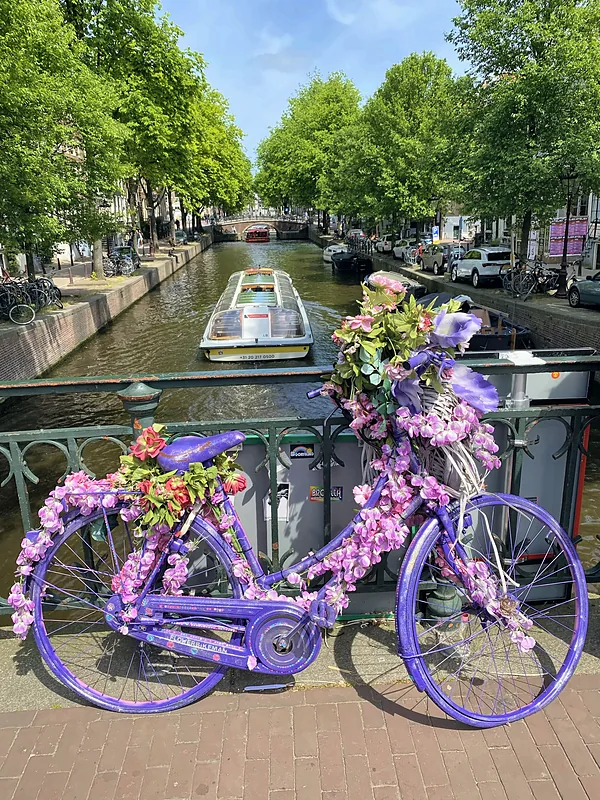 A flower-covered bike on a canal bridge